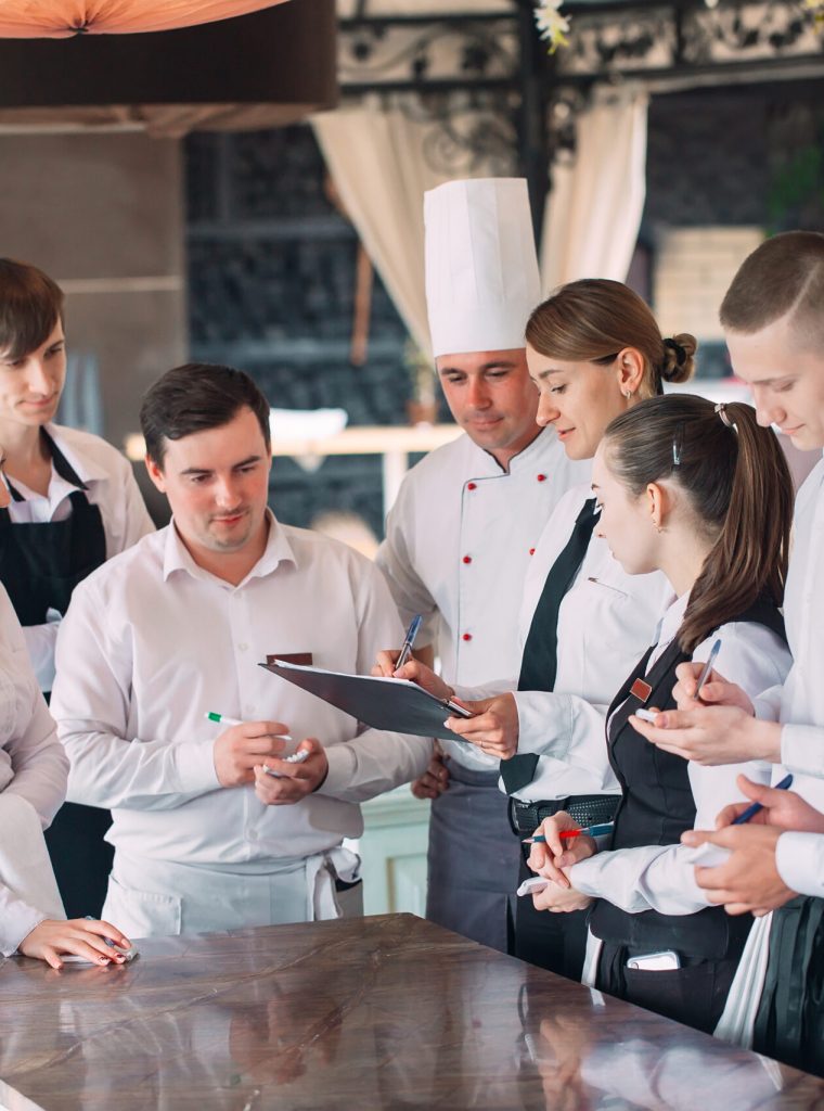 Restaurant manager and his staff in terrace. interacting to head chef in restaurant